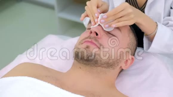 美容诊所女美容医生清洁面部手术的男人视频的预览图