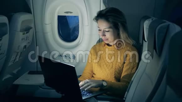 飞机飞行一个兴高采烈的女人在笔记本电脑上打字视频的预览图