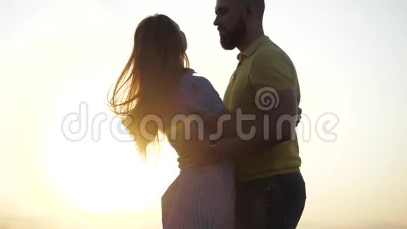 两个恋爱中的年轻恋人的幸福关系他们在耀眼的阳光下亲吻和拥抱特写视频的预览图