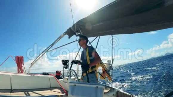 有轮子的人在游艇上航行的侧视年轻的男船长享受游艇度假视频的预览图