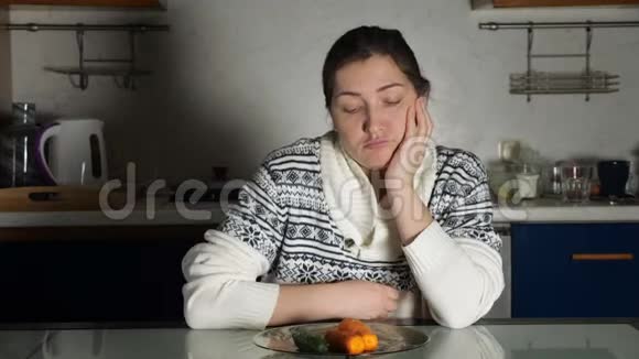 女孩坐在餐桌上看着盘子里的蔬菜视频的预览图