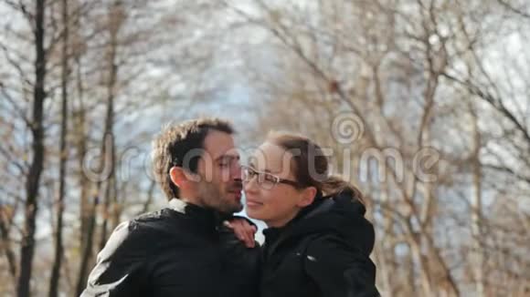 丈夫慢慢地亲吻妻子的脸颊站在一个舒适的秋天公园里彼此相爱彼此放松视频的预览图
