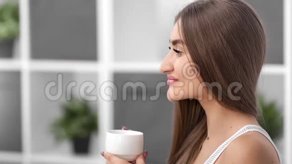 迷人的女人有着天然的美丽喝着咖啡拿着杯子4k红色相机特写镜头视频的预览图