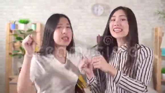 两个亚洲年轻女子在家唱卡拉OK视频的预览图