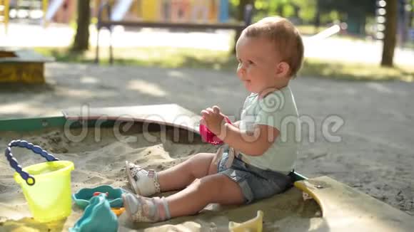 可爱的宝宝在操场沙箱里玩沙子视频的预览图