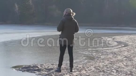 孤独的白种人站在湖岸上眺望远方自信的游客享受阳光明媚的秋日视频的预览图