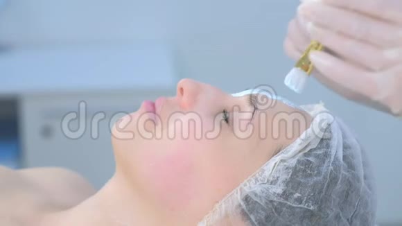 美容师用刷子在女性脸上涂上面部保湿面膜视频的预览图
