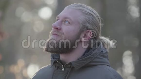 一位英俊的白种人灰色的眼睛呼吸着新鲜的空气男游客在秋天旅游视频的预览图