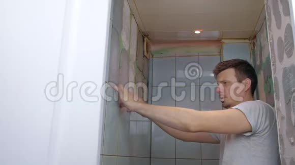 在家里做翻修的人瓦工在厕所里把墙上的瓦片去掉视频的预览图