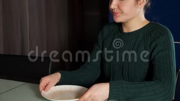 饥饿的女人吃午饭舔盘子里剩下的食物视频的预览图
