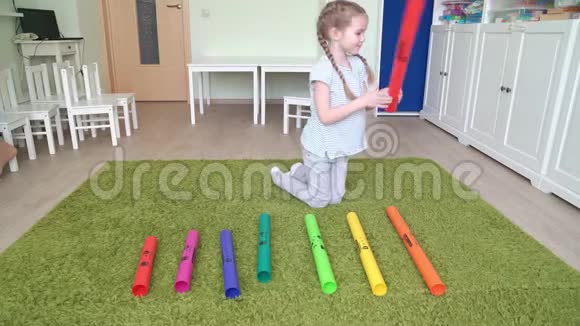 小女孩在玩五颜六色的音乐管视频的预览图