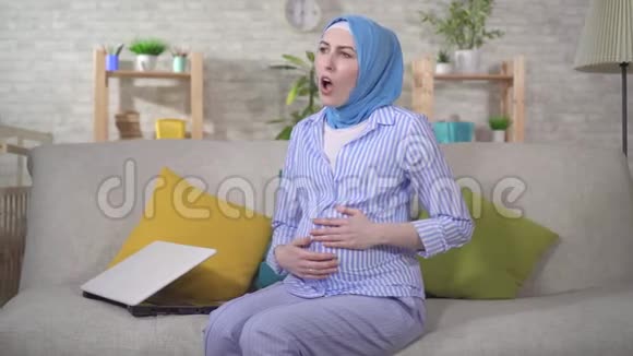 一名年轻的穆斯林孕妇在头巾上经历了产前宫缩视频的预览图
