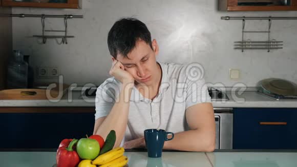 精疲力竭的家伙坐在桌旁抱着头睡着了视频的预览图