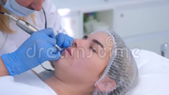 美容师用纹身机为女孩制作嘴唇微滑程序视频的预览图