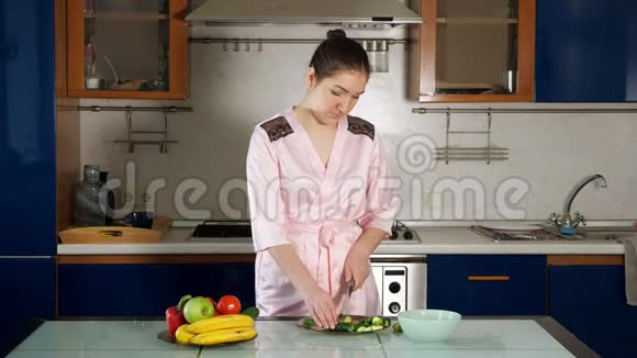 女孩站在桌子上做沙拉切蔬菜视频的预览图