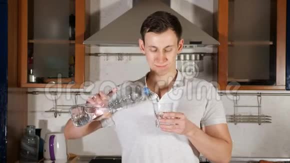 高个子男人往玻璃杯里倒水喝饮料解渴视频的预览图