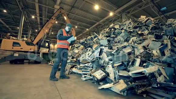 男工正在检查废弃电脑的部件垃圾垃圾废品回收厂视频的预览图
