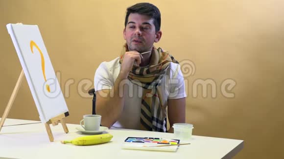 一位艺术家坐在桌子旁等待缪斯画一幅画视频的预览图