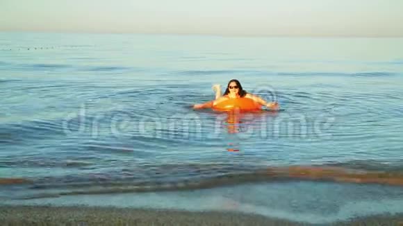 一个身穿泳装的黑发女人在靠近海岸的海域游泳视频的预览图