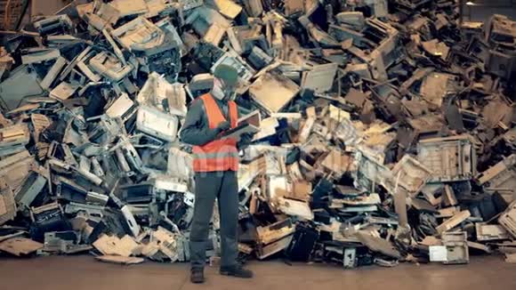 有一堆有缺陷的设备在垃圾场的男工垃圾塑料回收厂视频的预览图