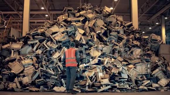 垃圾废品垃圾回收中心男员工正把办公室机器上的杂物扔进一堆视频的预览图