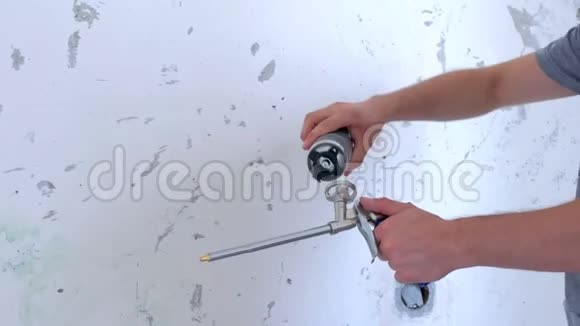 人施工工人将一瓶安装泡沫螺丝固定到工具上双手特写视频的预览图