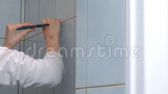女瓷砖在家进行翻新维修从厕所的墙壁上移除瓷砖视频的预览图