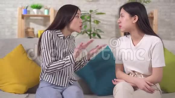 两个年轻的亚洲女人坐在客厅里吵架互相生气视频的预览图