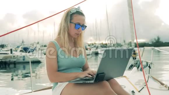 一位女士在港口用一台带游艇的笔记本电脑视频的预览图