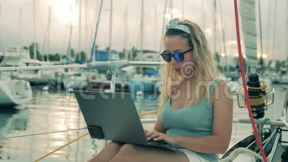 一个女人在船上浏览笔记本电脑视频的预览图