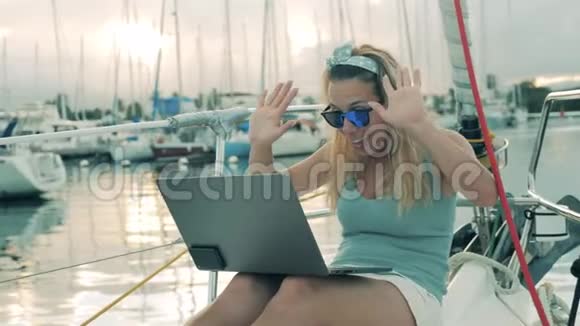 一个女人在从船上视频时挥手微笑视频的预览图