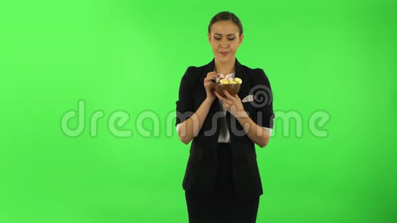 不开心的女孩很高兴地吃了一颗多颜色的糖果绿色屏幕视频的预览图
