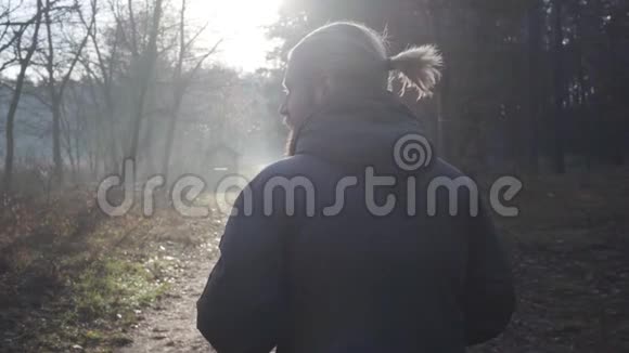 白种人成年男性游客站在秋林阳光下的后景孤独的人在享受旅行视频的预览图