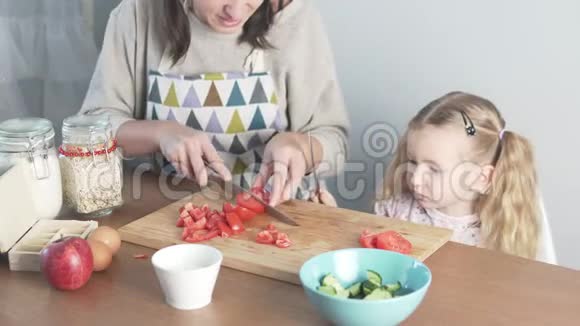 妈妈和可爱的小女儿切西红柿视频的预览图