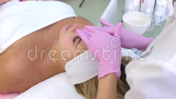 手套美容师用凝胶清洗客户女人的脸脖子和胸部视频的预览图