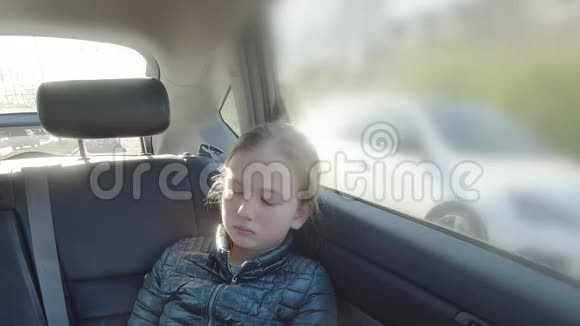 无聊的女孩坐在汽车后座看着智能手机1视频的预览图