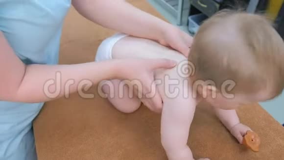 专业医生按摩师为婴儿做背部脊柱按摩视频的预览图