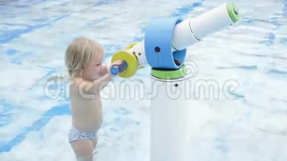 可爱的小女孩在游泳池里玩水炮视频的预览图