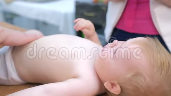医生按摩师在躺在沙发上的诊所里给肚子上的婴儿做按摩视频的预览图