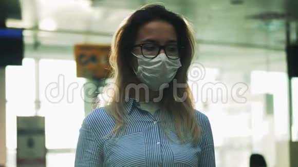 一个戴着医用面具和眼镜的女人通过玻璃被拍摄下来冠状病毒流行感染的概念视频的预览图