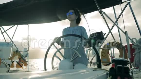年轻女子站在帆船的车轮前女船长帆船视频的预览图