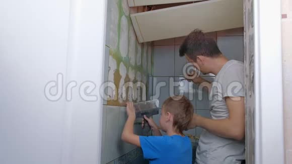 爸爸和儿子做家庭装修男孩移除瓷砖男人修理电力视频的预览图