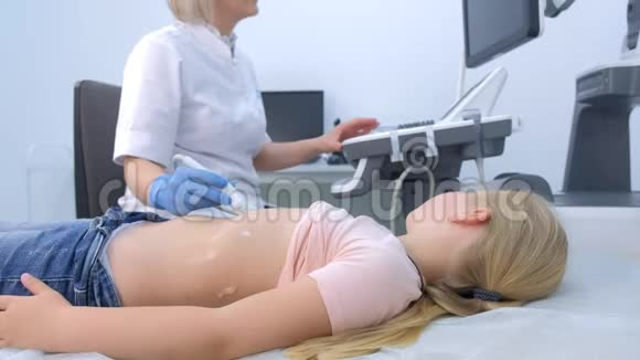 医生正在用侧视图扫描仪为小女孩做腹部超声检查视频的预览图
