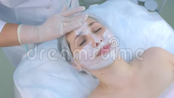 美容师正在美容诊所为女性面部敷面膜视频的预览图