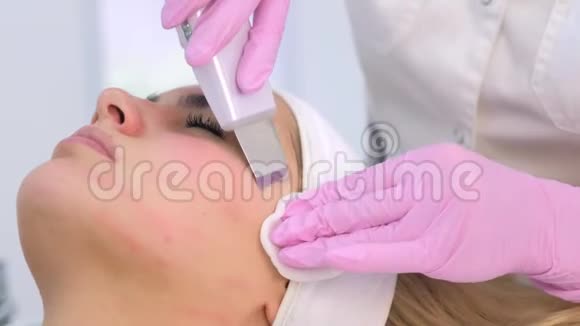 美容师为临床上的年轻女性做超声清洗手术视频的预览图
