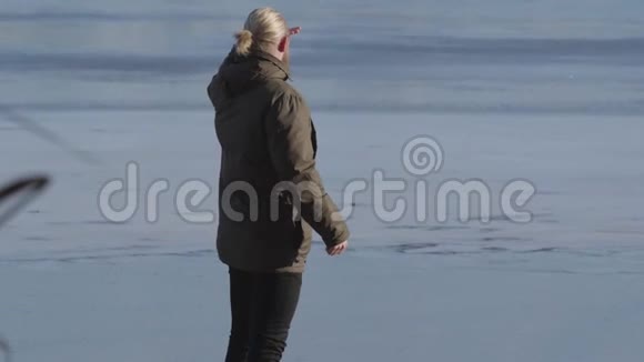 自信的金发白种人站在湖岸上手牵着额头望着远处成人视频的预览图