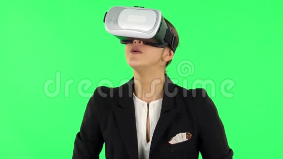 拥有虚拟现实耳机或3D眼镜的快乐年轻女性绿色屏幕视频的预览图