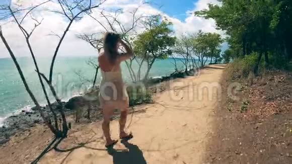 一个女人在度假时走在海滩附近视频的预览图