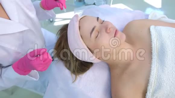 美容师用针头和擦拭棉垫戳女人脸上的痤疮视频的预览图