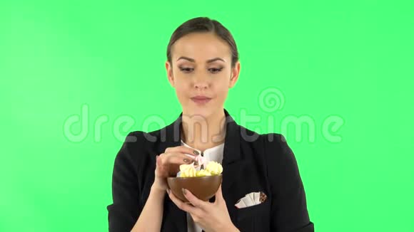快乐的女孩一边吃着一大块五颜六色的糖果一边享受绿色屏幕视频的预览图